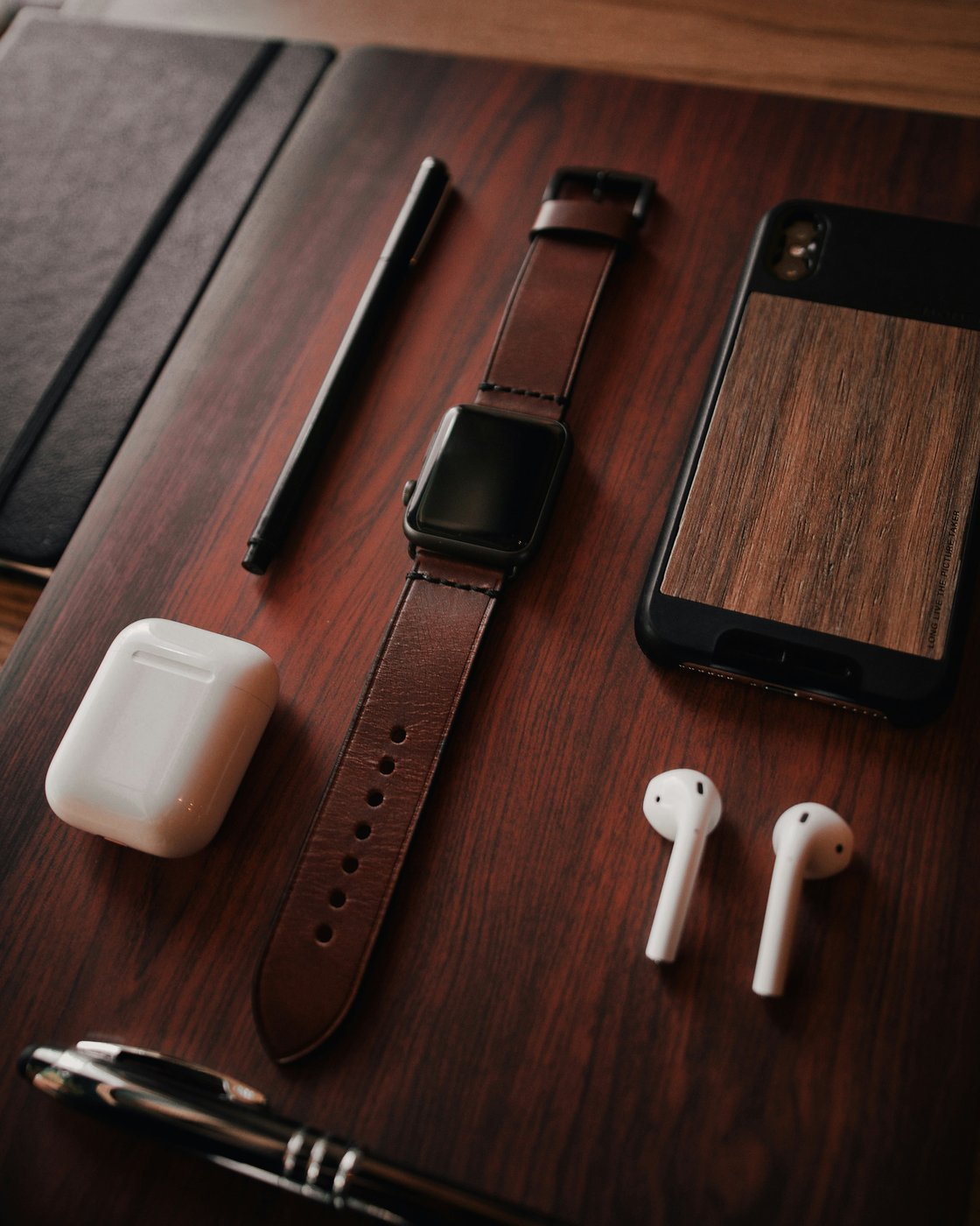 iPhone and wireless earbuds on a wooden surface